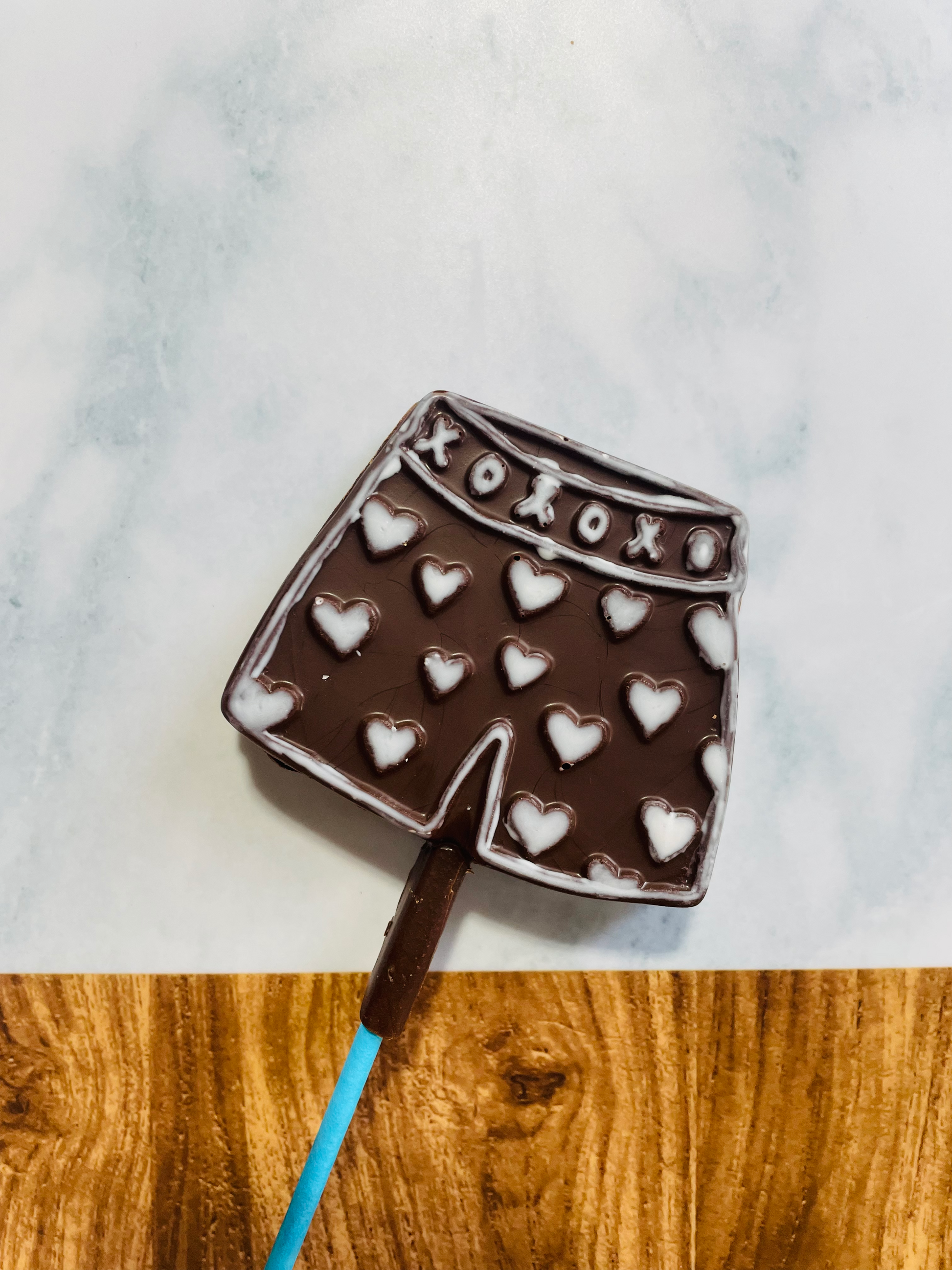 QUEST XO Dark Cheekly Lolly: Boxer shorts lolly with white hearts on an intricate background.