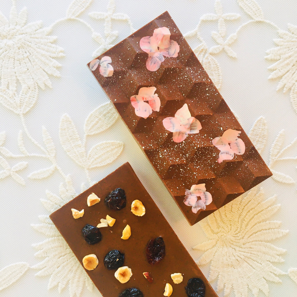 QUEST XO Hazel Chai Bar: Two nutty chocolate bars on a cream colored floral background.