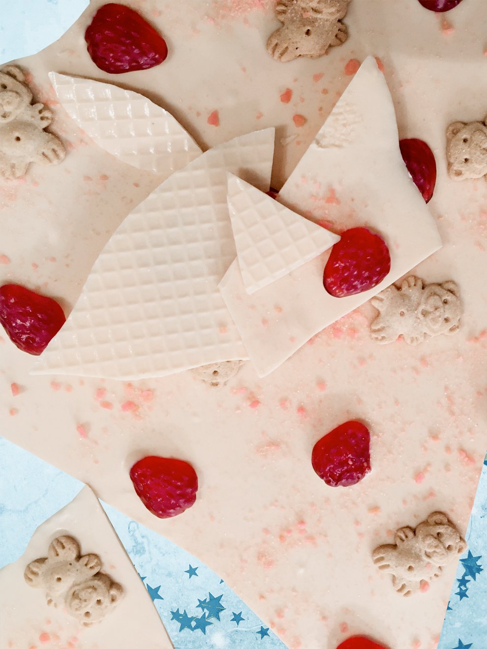 QUEST XO Berry Cheesecake Bark: Pieces of white chocolate with teddy bears on it placed on top of white chocolate.
